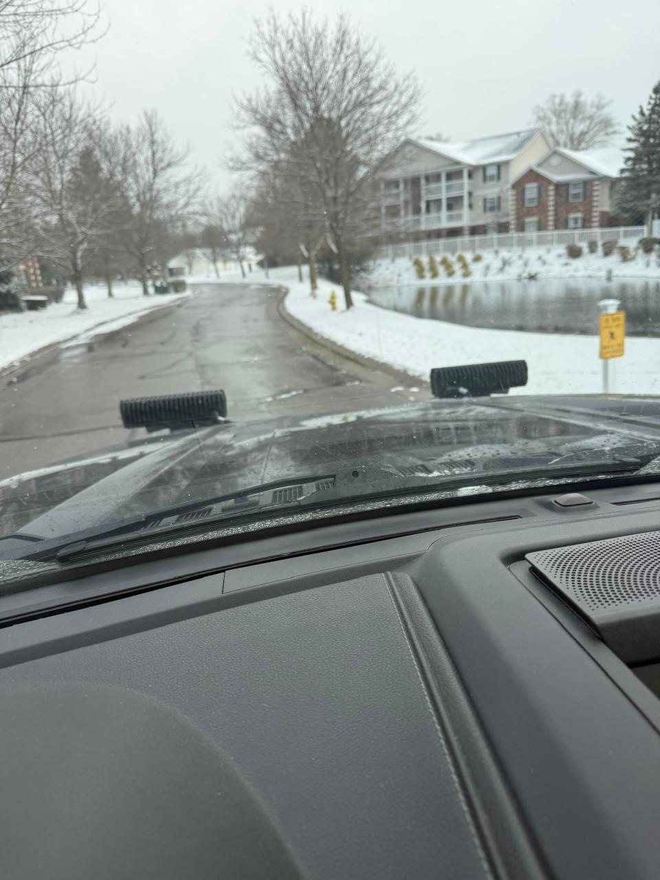 Freshly cleared road through an apartment community next to a pond
